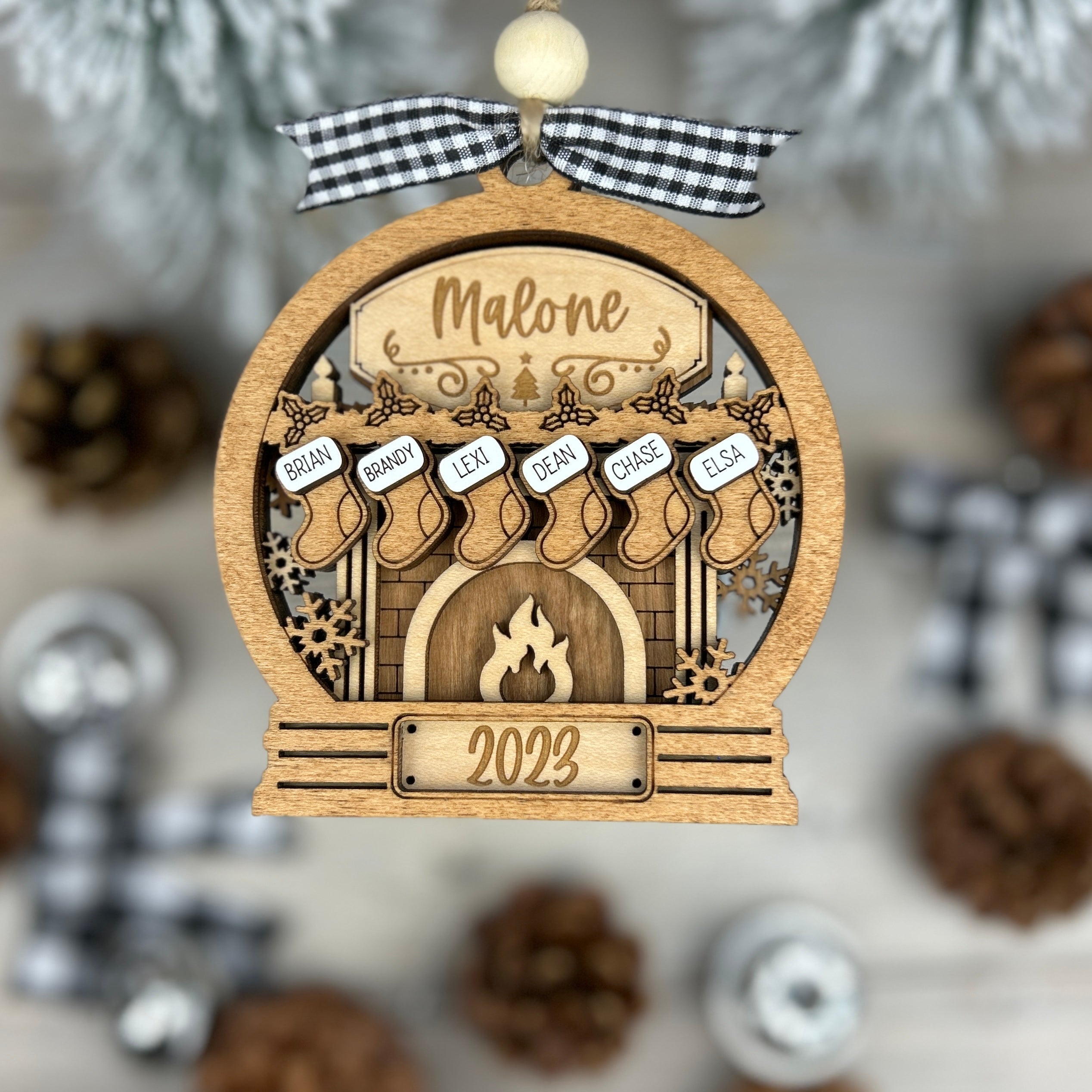 Personalized Christmas ornament with family stockings hanging from a fireplace.