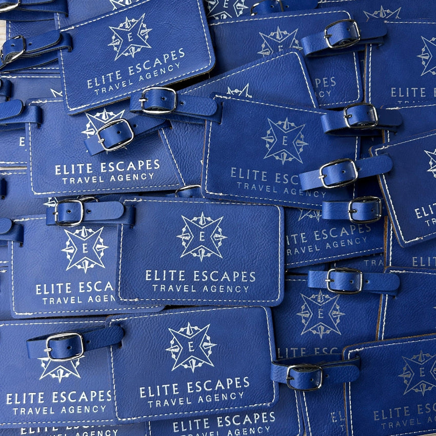 Multiple blue luggage tags with 'Elite Escapes Travel Agency' branding.