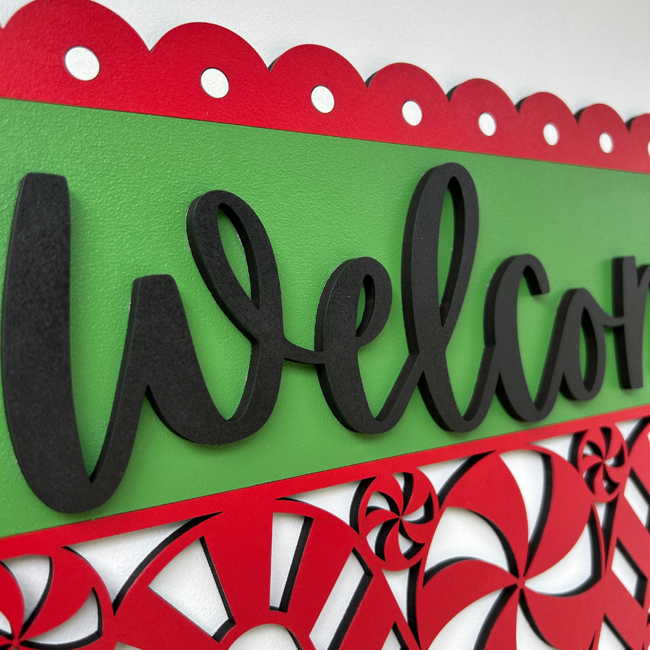 Decorative 'Welcome' sign with red and green colors and candy cane design.