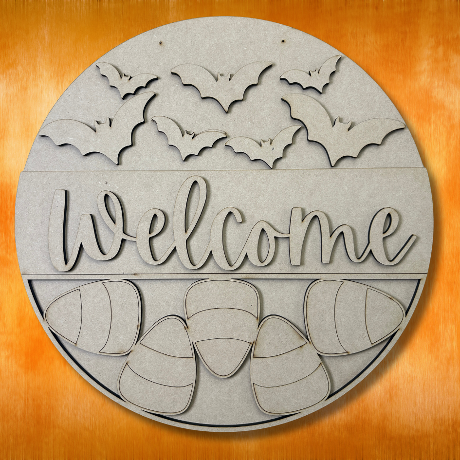 Round wooden sign with 'Welcome' text and bat and pumpkin designs on a wooden background