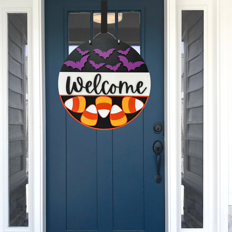 Halloween-themed door decoration with candy corn and bats on a blue door.