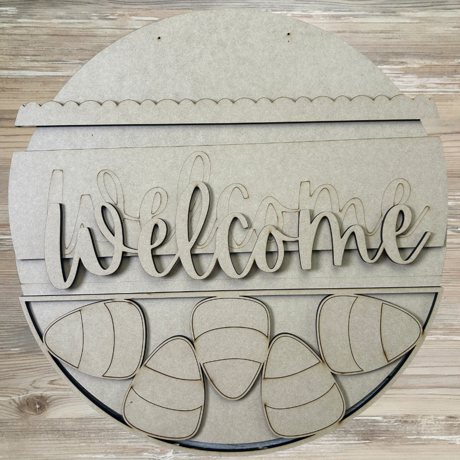 Wooden 'Welcome' sign with decorative elements on a wooden background