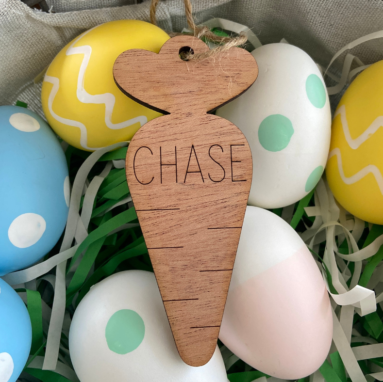 Wooden carrot-shaped tag with 'CHASE' engraved, surrounded by colorful Easter eggs.