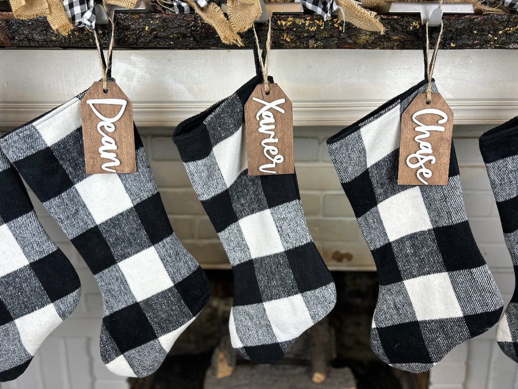 Family stocking tags hanging by a fireplace.