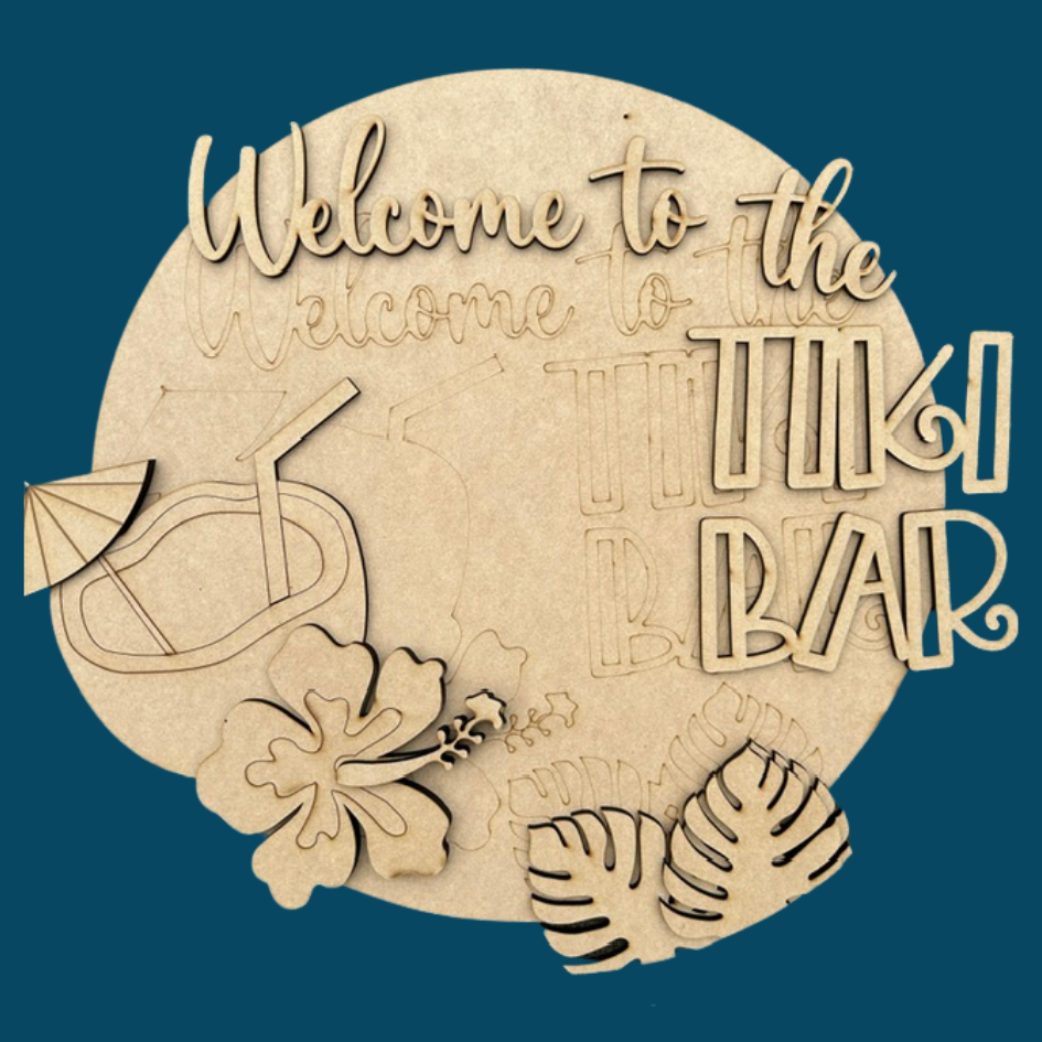 Wooden decorative sign with 'Welcome to the Tiki Bar' text on a blue background. Pieces shown slightly off the backer for a DIY project.