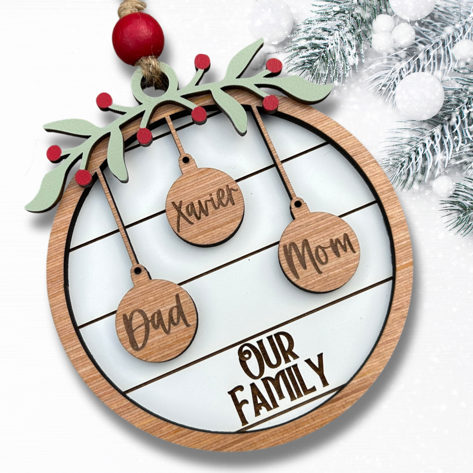 Wooden family ornament with engraved names on a white background