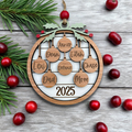 Wooden family tree ornament with names and year, surrounded by cranberries and pine branches on a wooden surface.