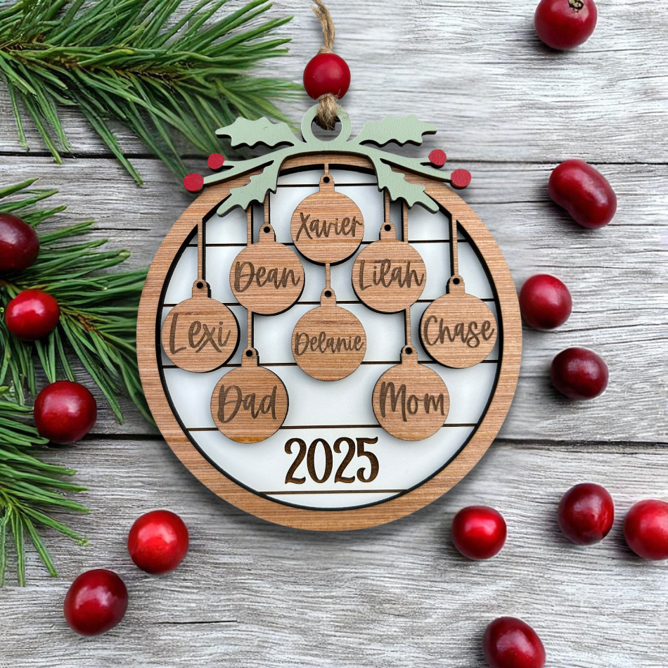 Wooden family tree ornament with names and year, surrounded by cranberries and pine branches on a wooden surface.