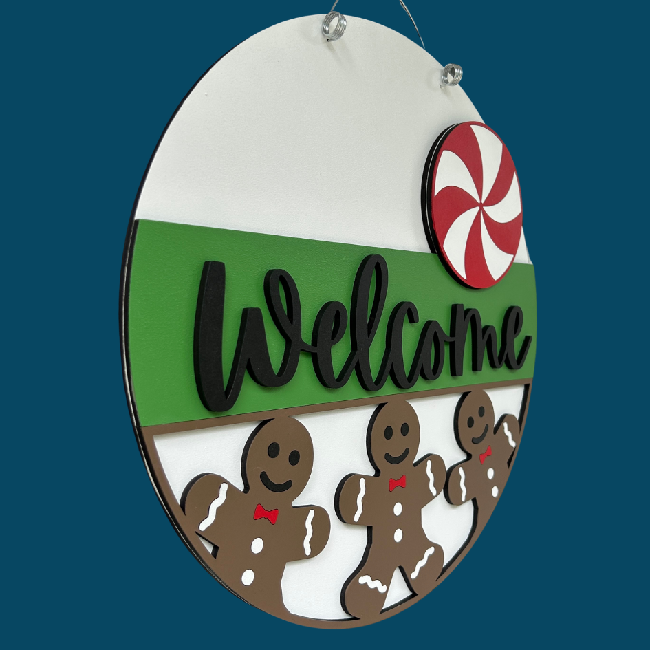 Decorative sign with gingerbread men and a candy cane on a blue background