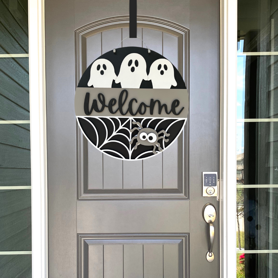 Halloween ghost sign hanging on a front door.