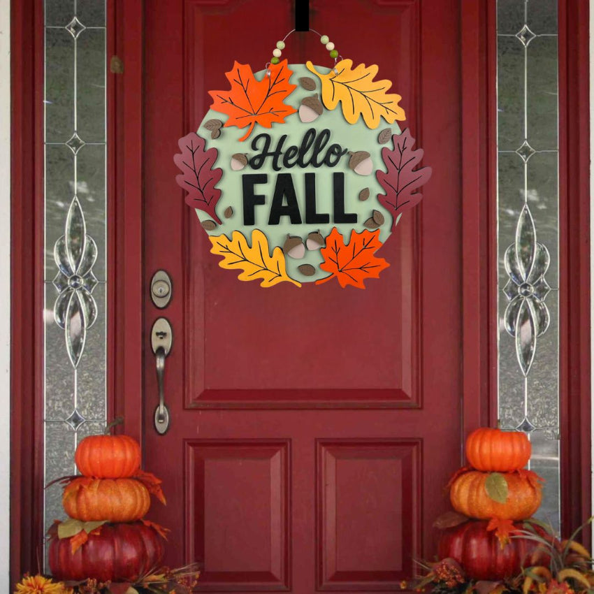 Decorative wreath with 'Hello Fall' text on a red door with pumpkins and autumn leaves.
