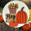 Fall pumpkin door sign with fall flowers and Hey on a wooden crate.