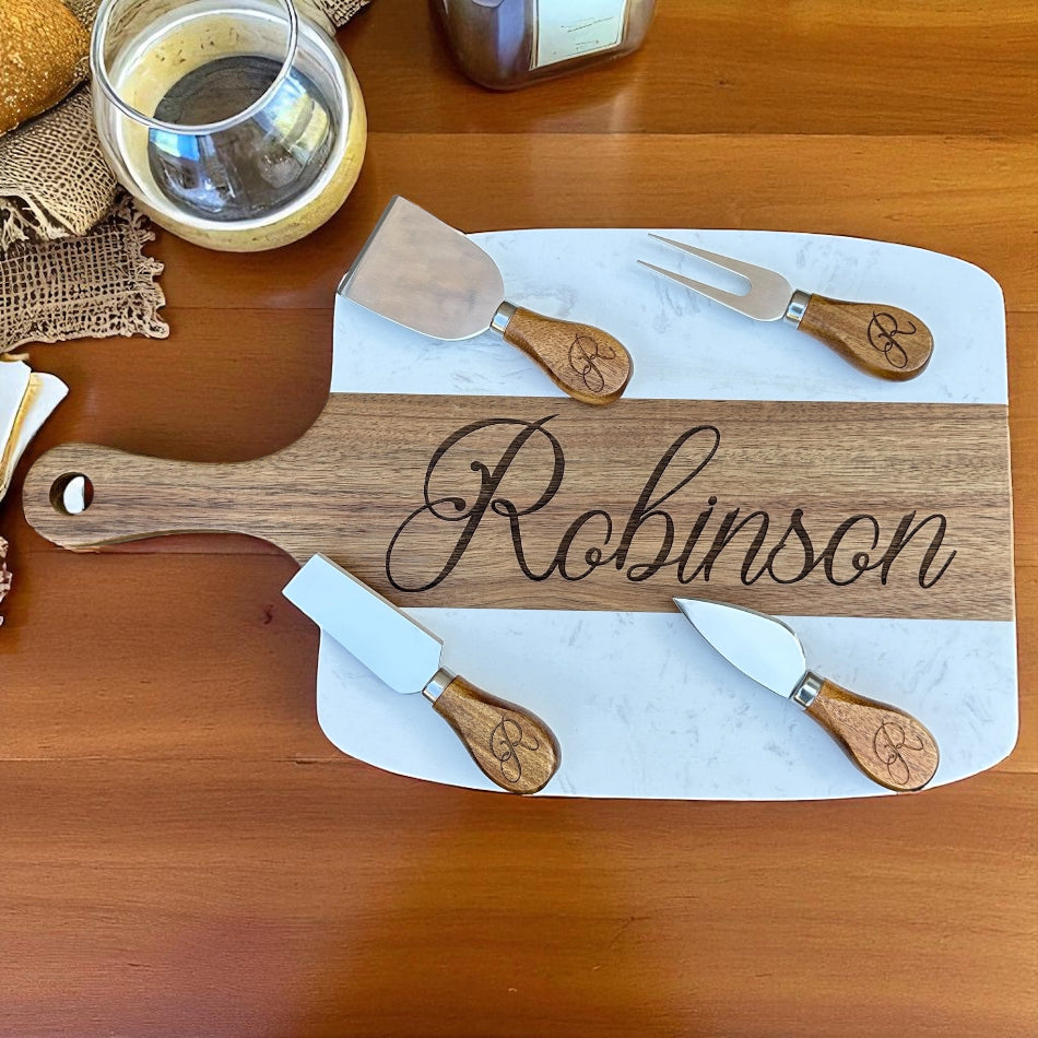 Wooden cutting board with engraved name 'Robinson' on a wooden surface with cutlery.
