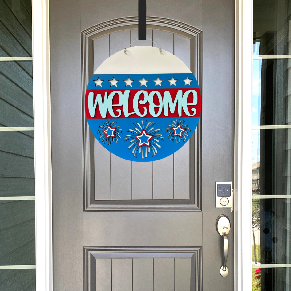 Decorative 'Welcome' sign with stars and stripes on a gray door