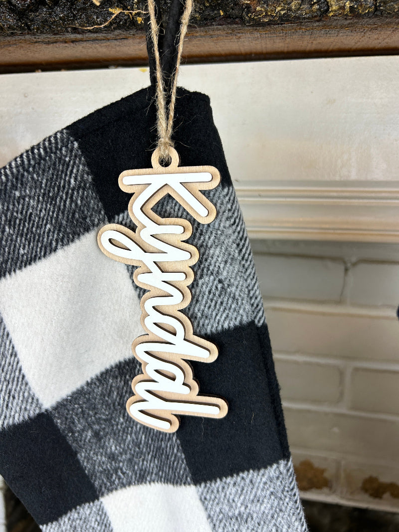 Close up of the stocking name tag showing the wood backer and white top layer of the name.