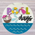 Pool Days summer door sign with beach balls and a coconut drink.