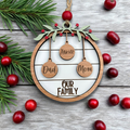 Decorative Christmas ornament with 'Dad', 'Mom', and 'Xavier' on a wooden circle, surrounded by cranberries and pine branches.
