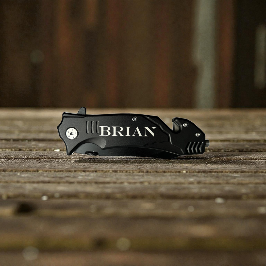 Black pocket knife with 'BRIAN' branding on a wooden surface