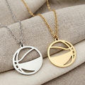 Two necklaces with circular pendants on a beige fabric background