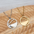 Two basketball necklaces, one silver and one gold, on a wooden surface.