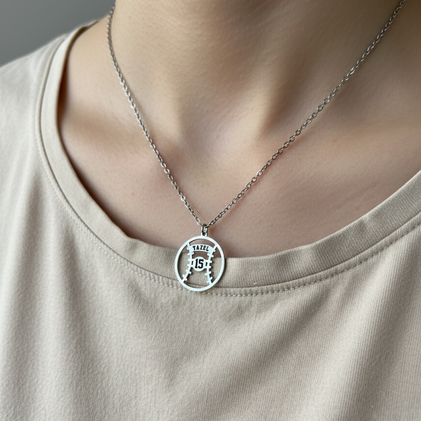 Necklace with a circular baseball pendant worn by a person on a plain background.