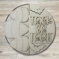 Circular wooden cutout with 'Trick or Treat' text and bat shapes on a wooden background