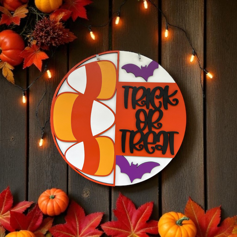 Halloween-themed decorative sign with pumpkins and bats on a wooden background.