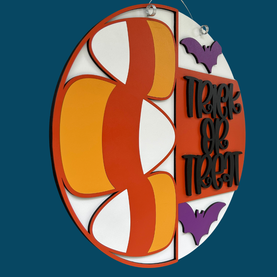 Halloween-themed decorative sign with candy corn design and 'Trick or Treat' text on a blue background.