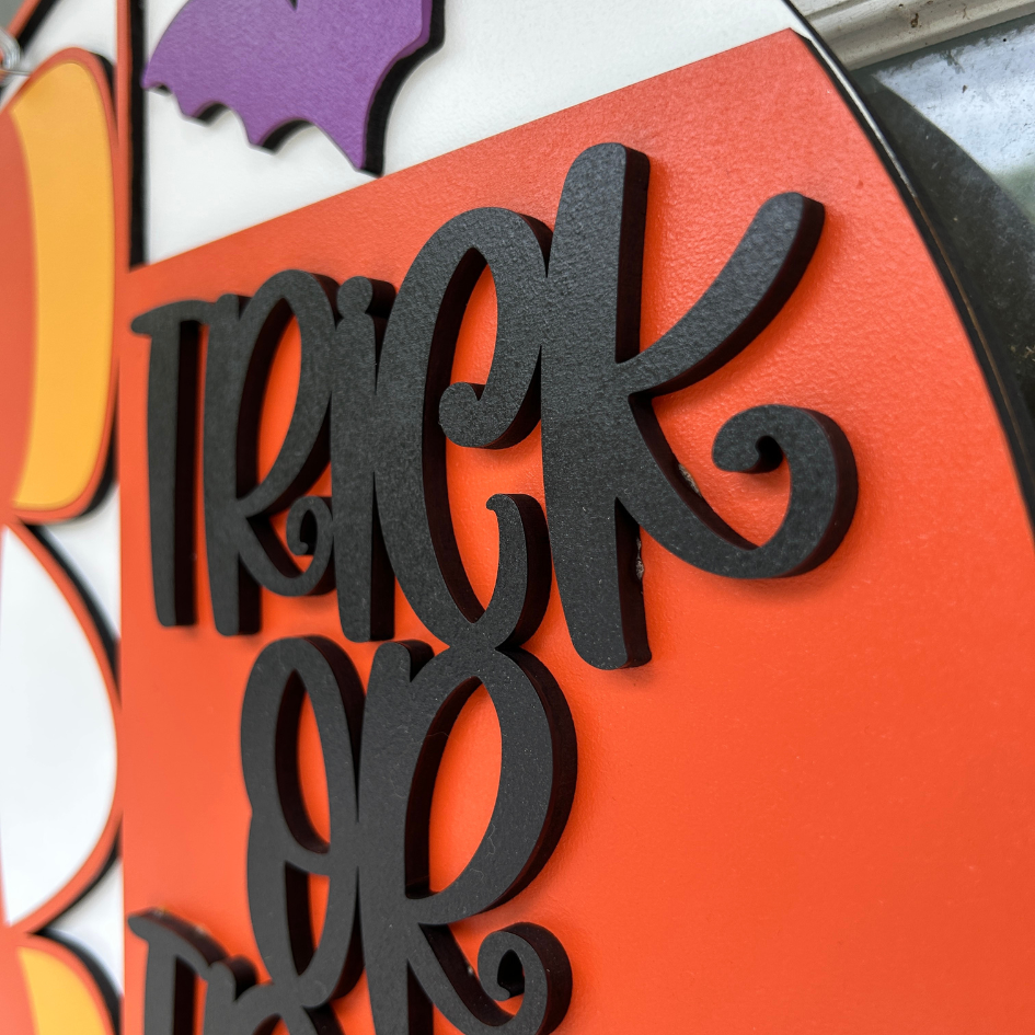 Black 'Trick or Treat' text on an orange background with Halloween-themed decorations.