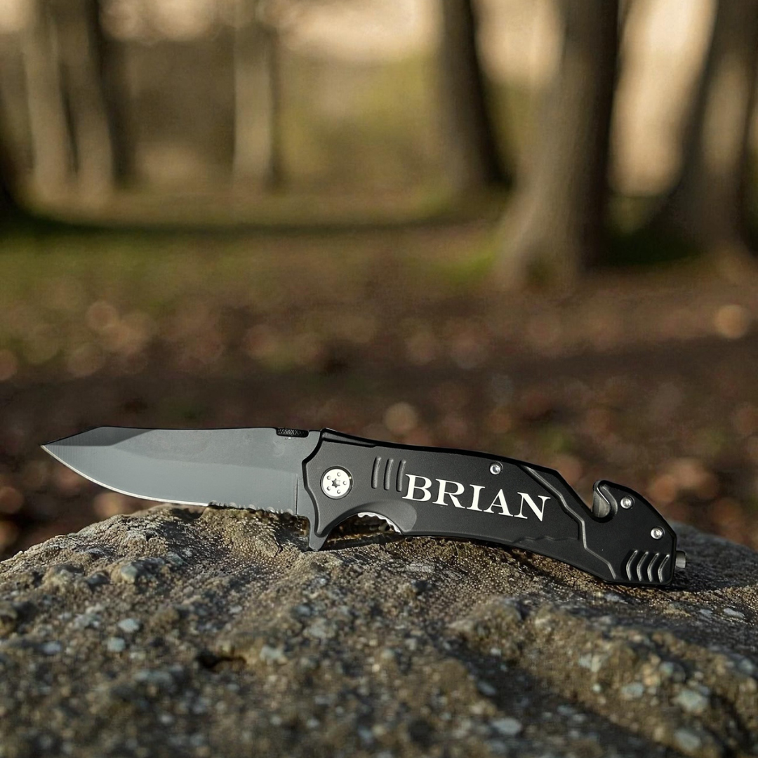 Folding knife with 'BRIAN' engraving on a rock, blurred natural background