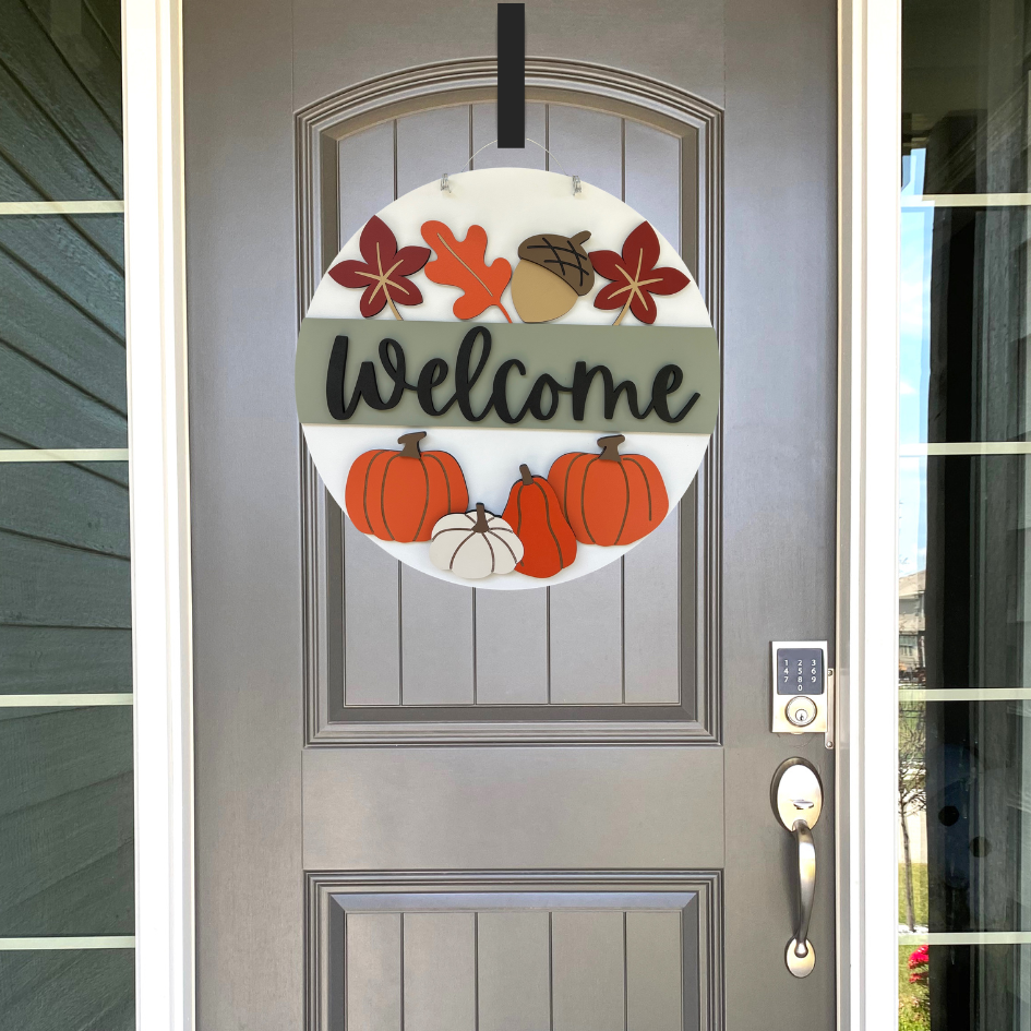 Fall welcome sign hanging on a front door.
