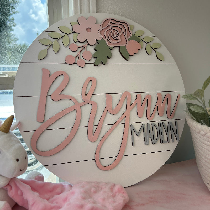 Baby name sign with pink flowers.