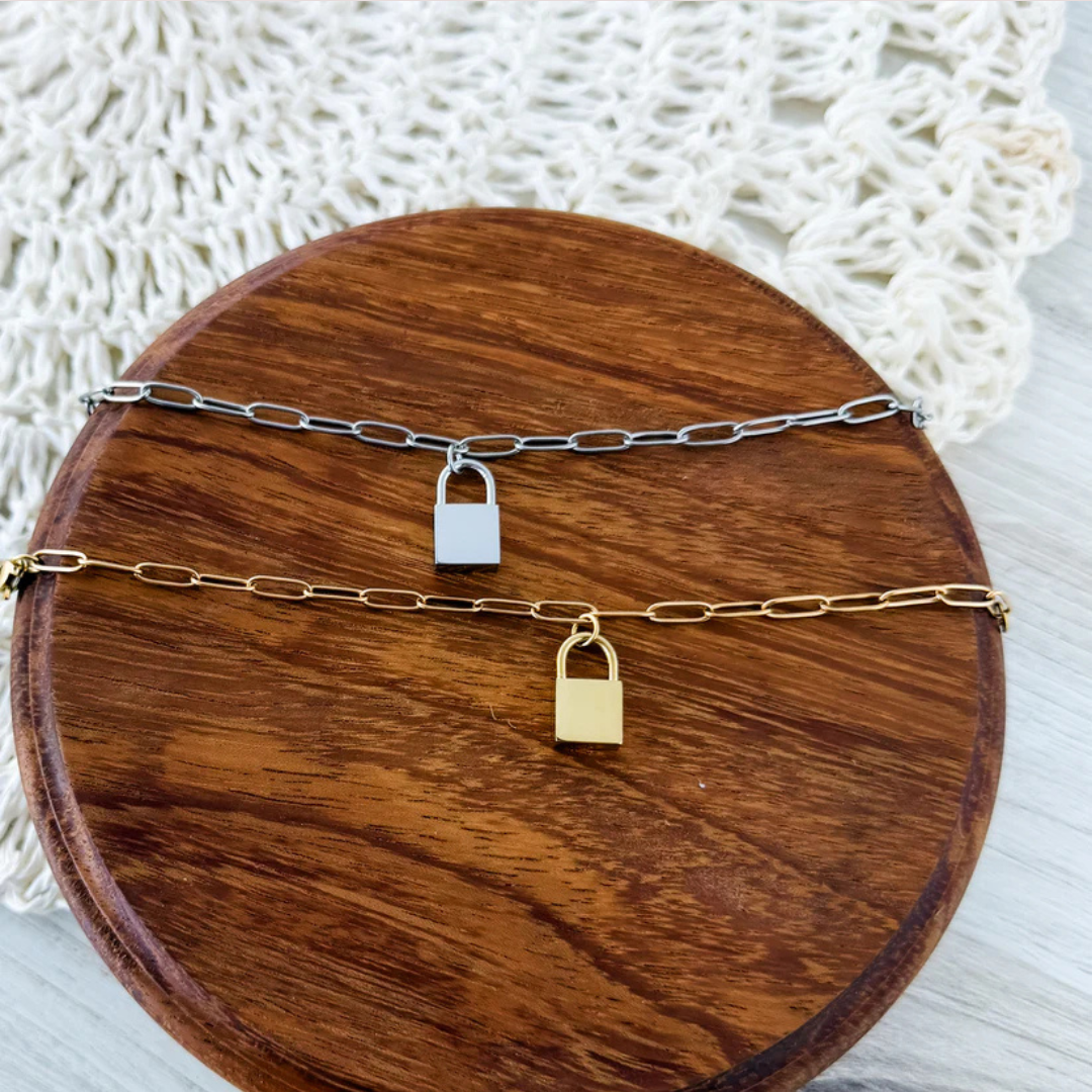 Lock bracelets in silver and gold ready for engraving laid on a wooden surface.