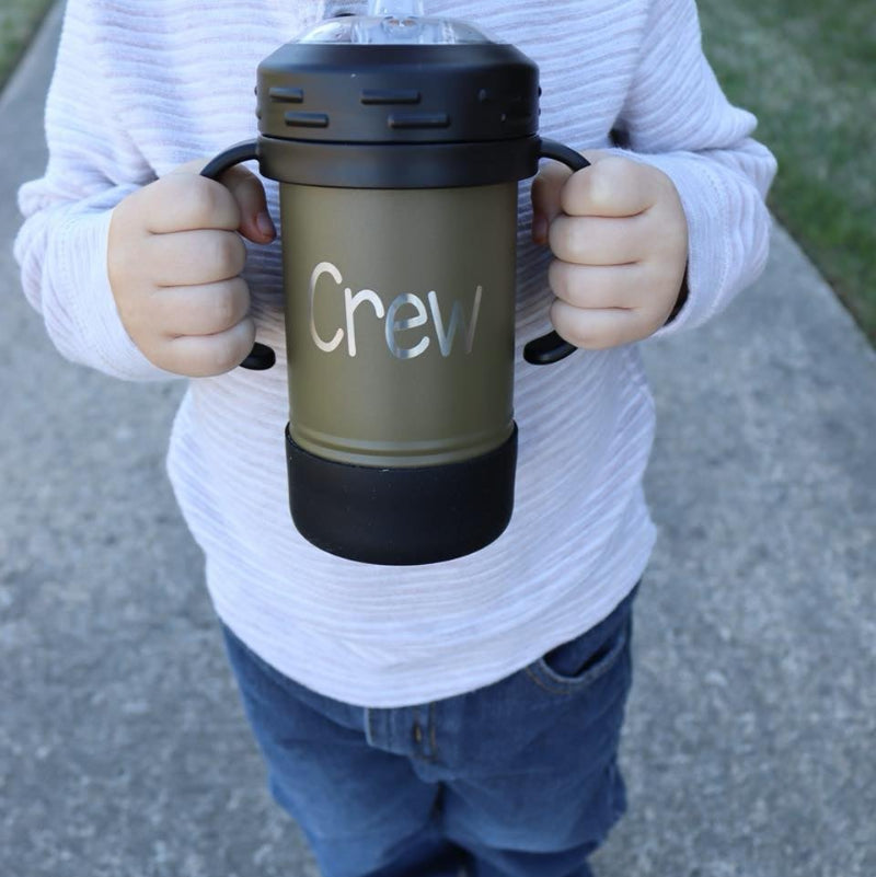 Child holding a sippy cup with their name engraved.