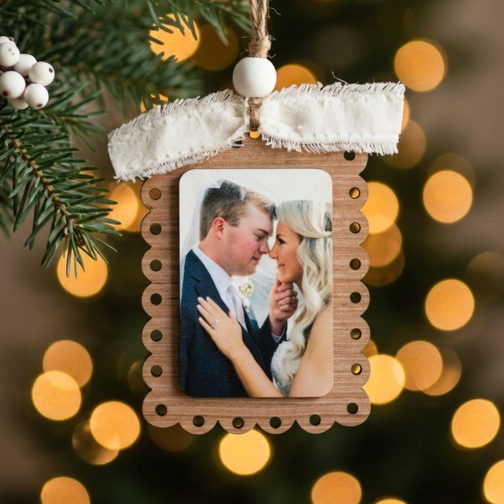 Decorative ornament with a couple's photo on a blurred Christmas lights background