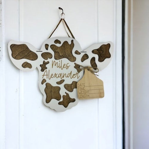 Sign in the shape of a cow head with an ear tag where you can write the new baby stats.