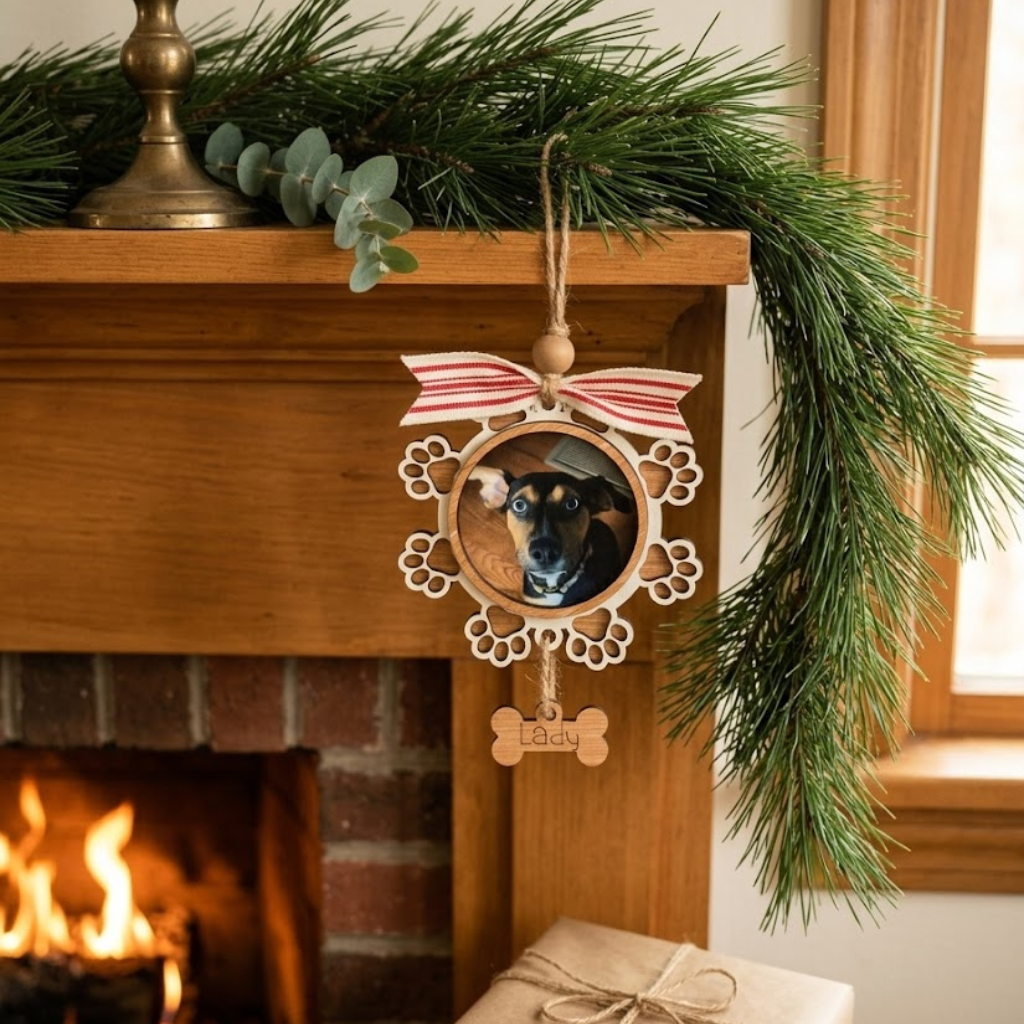 Decorative Christmas ornament with a dog's photo on a fireplace mantle with greenery and a gift.
