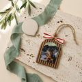 Decorative ornament with a photo of a dog on a textured surface with greenery.