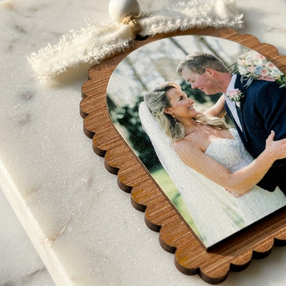 Wooden ornament with a photo of a bride and groom on a marble surface