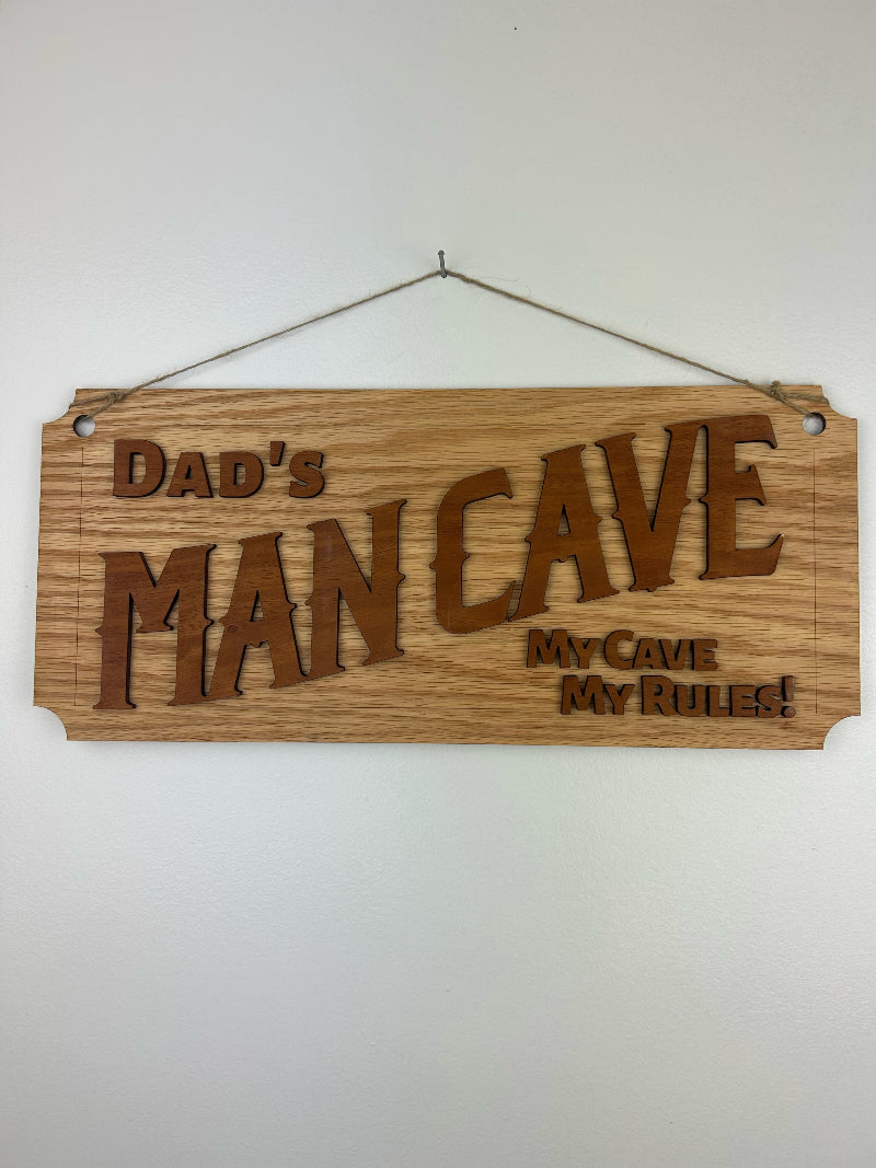 Dad's man cave sign carved out of wood and hanging on a wall.