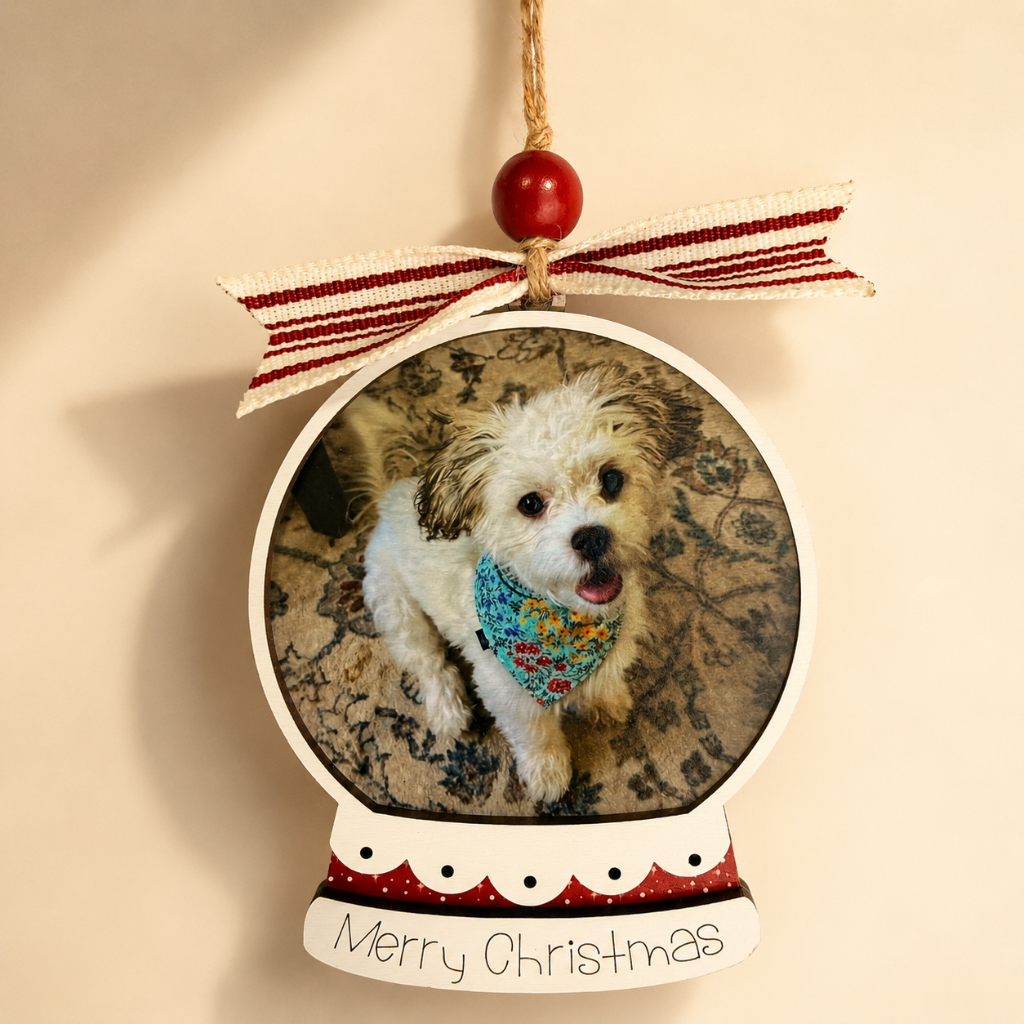 Personalized Christmas ornament with a dog's photo inside, featuring a red ribbon and 'Merry Christmas' text.