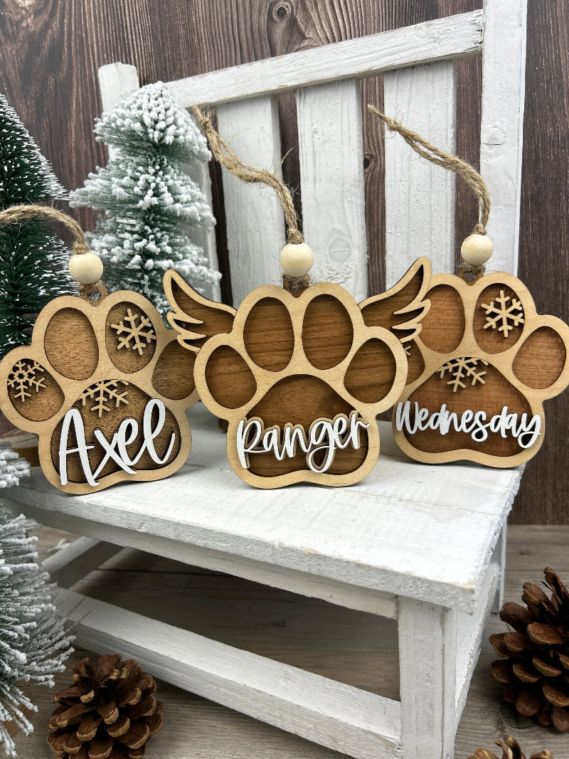 3 dog paw ornaments showing the normal paw and a paw with wings. All 3 have a dogs name on them.