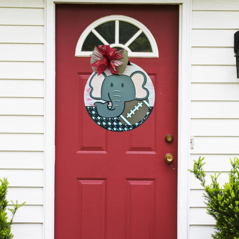 Elephant, football and houndstooth door sign hanging on a red door.