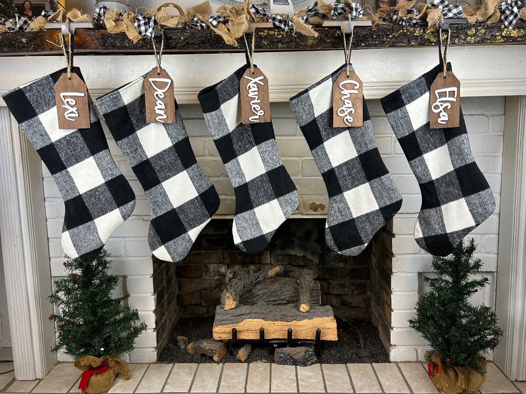 Family stocking tags hanging by a fireplace.
