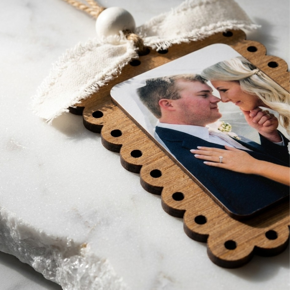 Wooden photo frame with a couple's photo on a marble surface