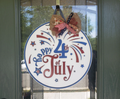 Patriotic 4th of July sign hanging on a door.