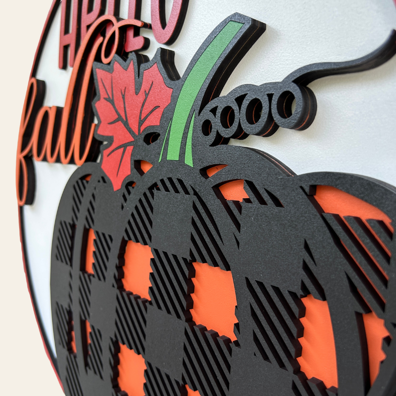 Decorative wall art with a pumpkin and 'Hello Fall' text on a white background