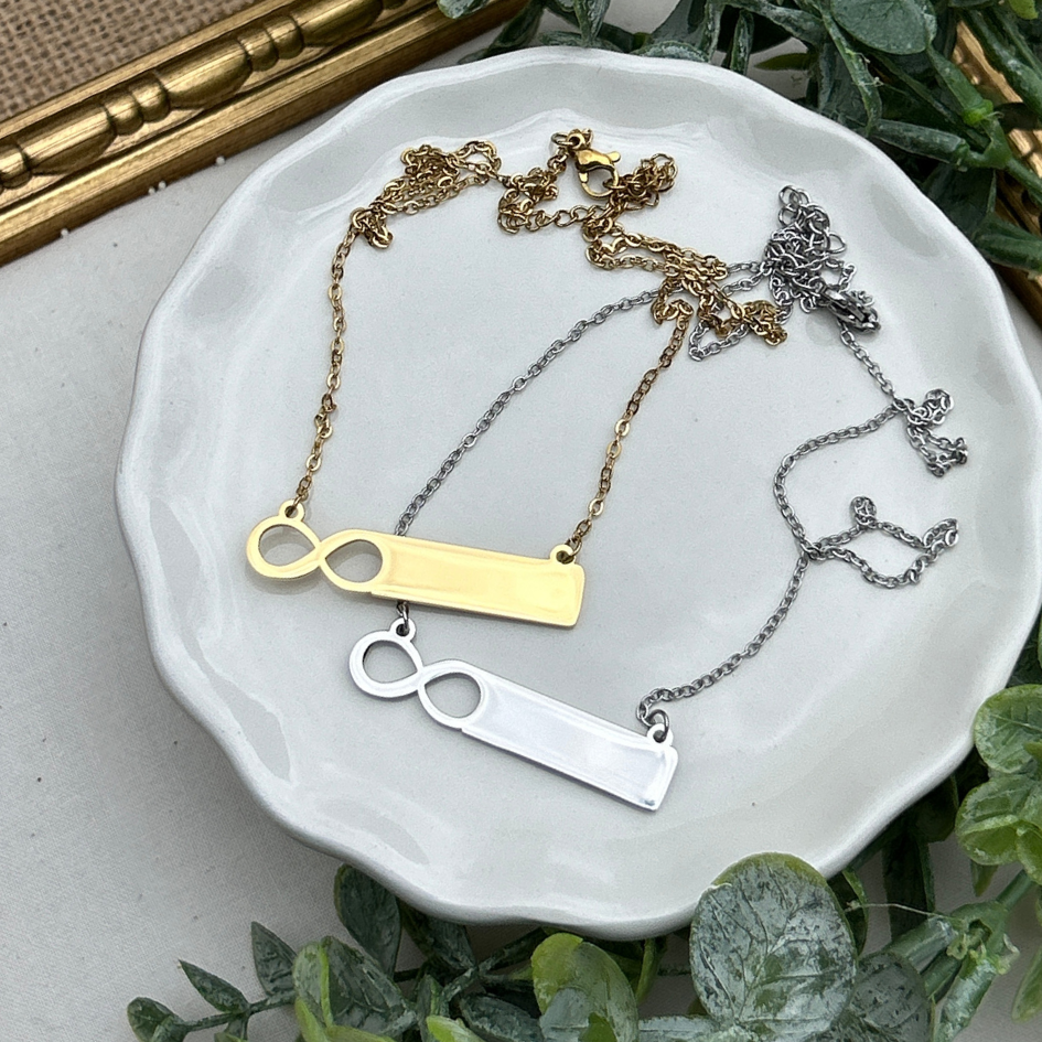 Three necklaces on a white dish with a gold frame and greenery in the background