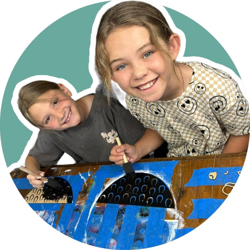 2 children painting their own name sign.