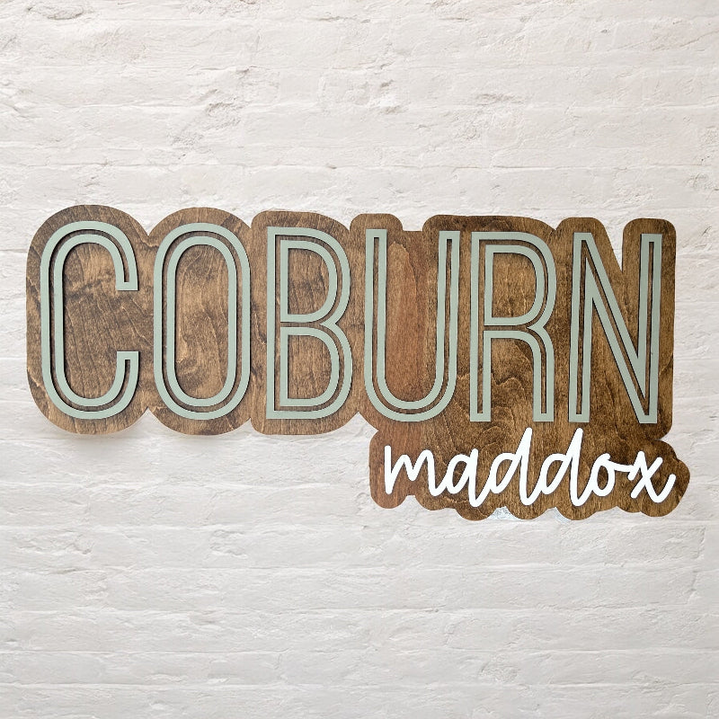 Baby Name cut out and outlined with a wood backer.